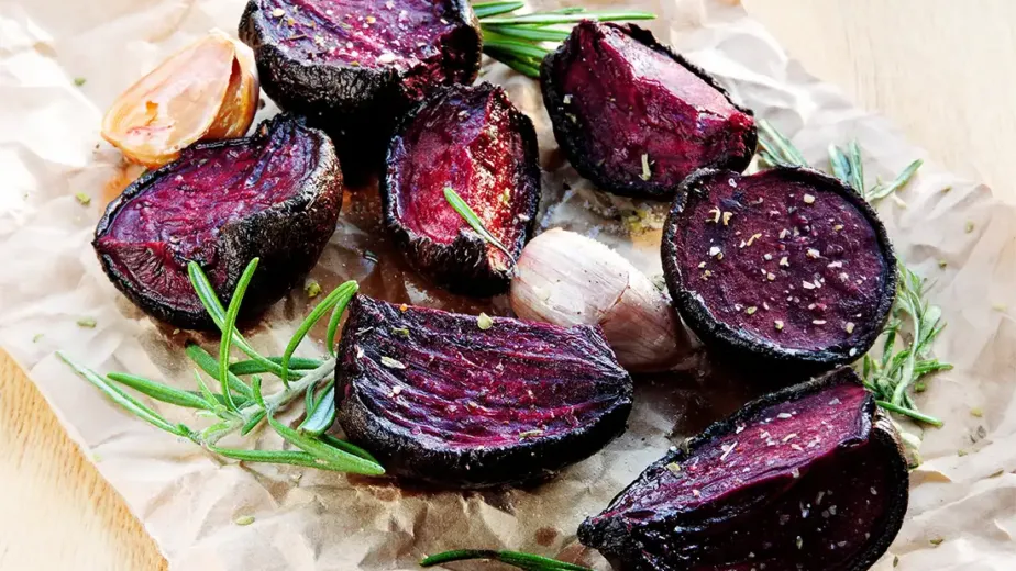 Remolacha asada al rescoldo servidas sobre pasta de sésamo negro.